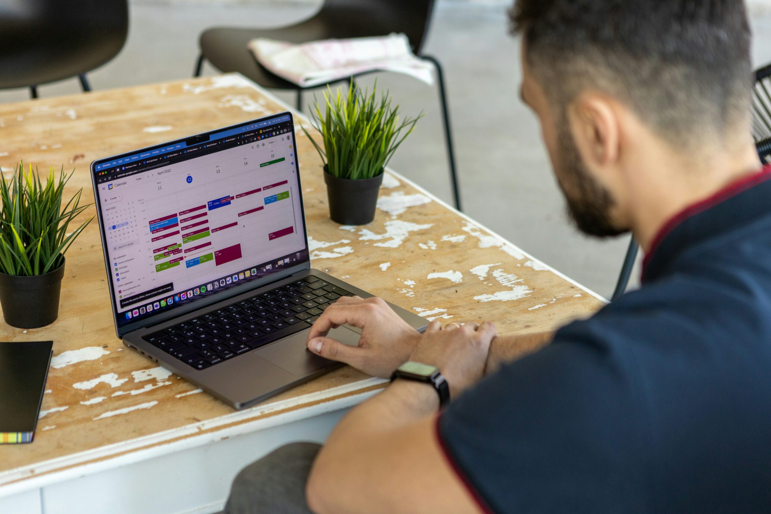 Uomo adulto concentrato su un'agenda aperta in uno spazio di lavoro ordinato, a rappresentare il metodo del Professional Organizer applicato alla gestione del tempo del cliente