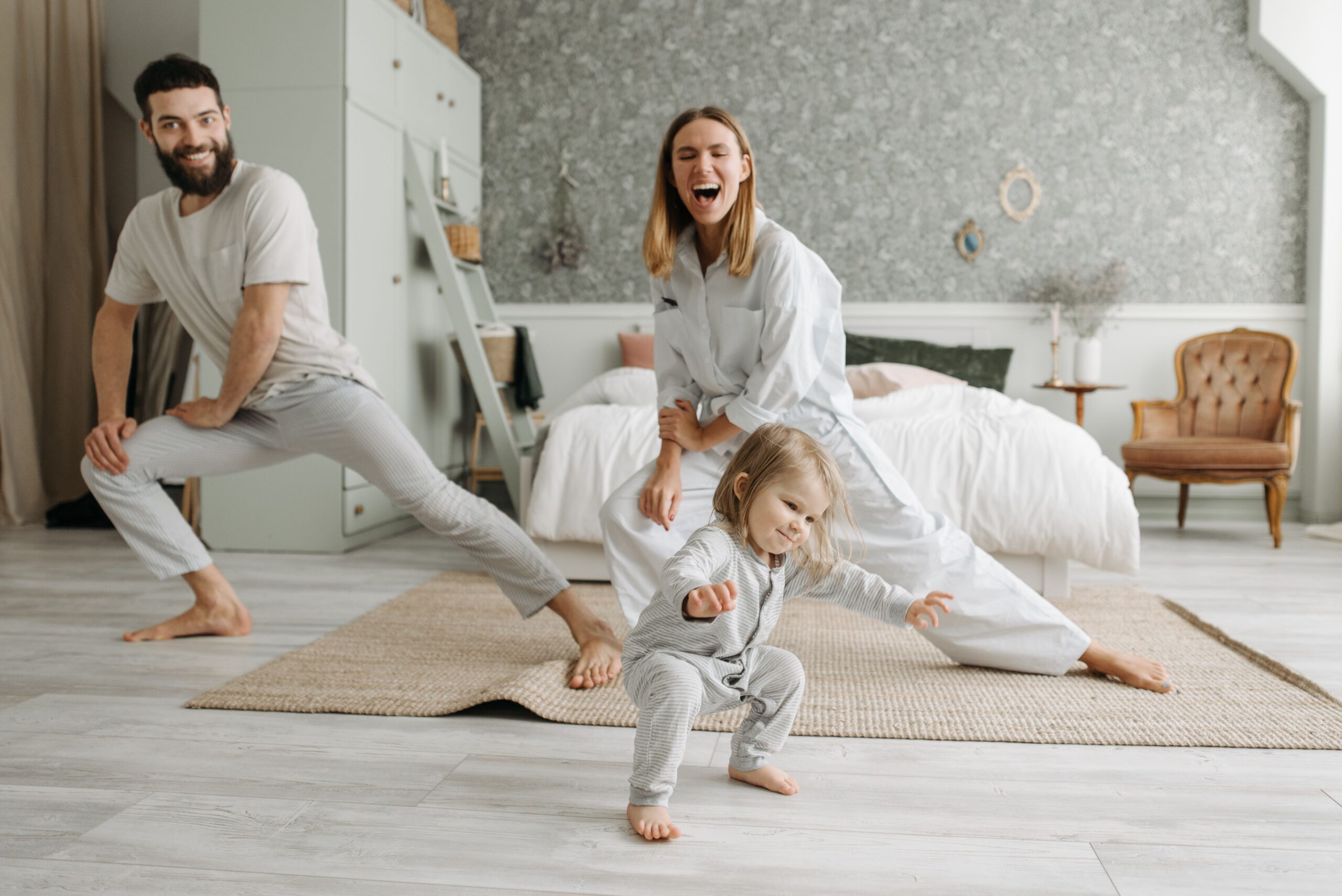 Famiglia con bambina piccola che gioca e ride in camera da letto — la vita quotidiana in famiglia che il Professional Organizer aiuta a rendere più fluida