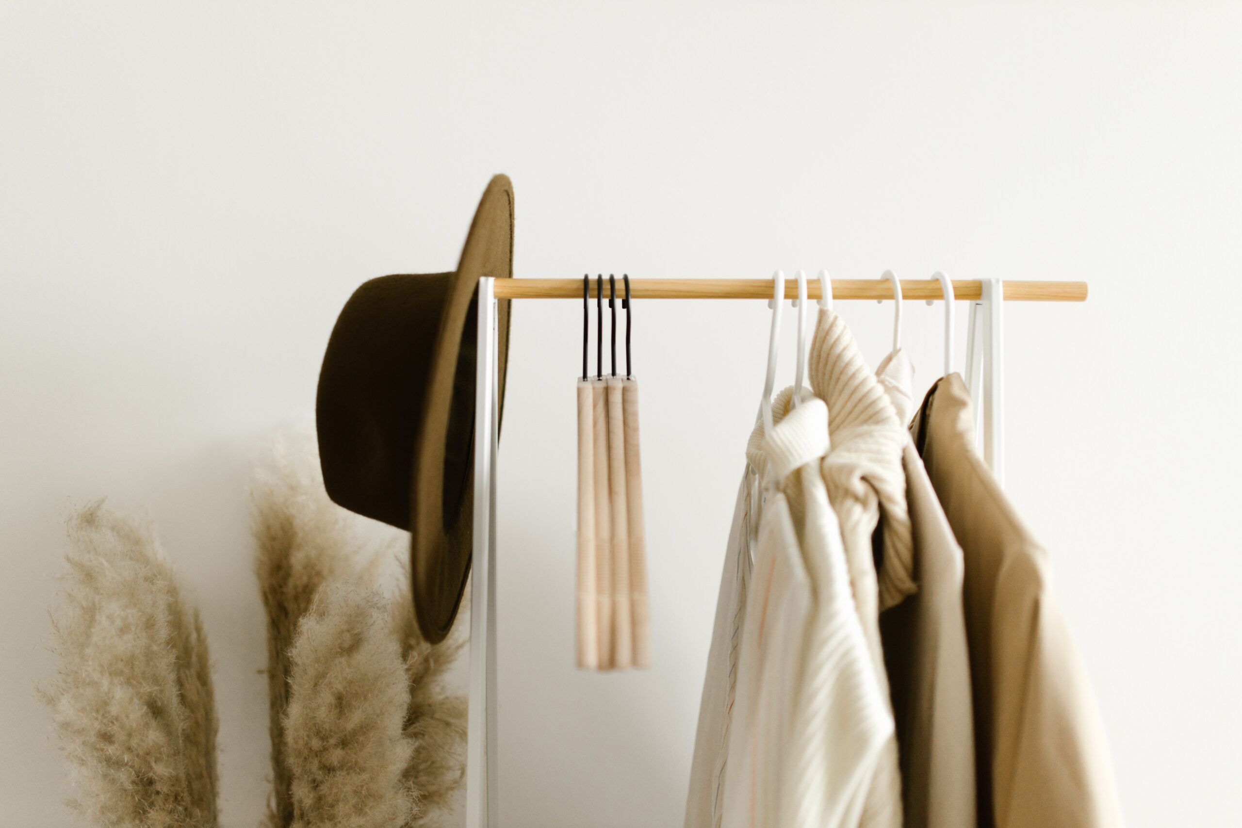 Appendiabiti minimal con capi neutri e cappello — il guardaroba ordinato dopo il cambio stagionale con il metodo del Professional Organizer